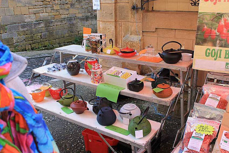 Vibrant market stall displaying colorful fresh produce and artisanal goods at Villefranche-du-Perigord Saturday market