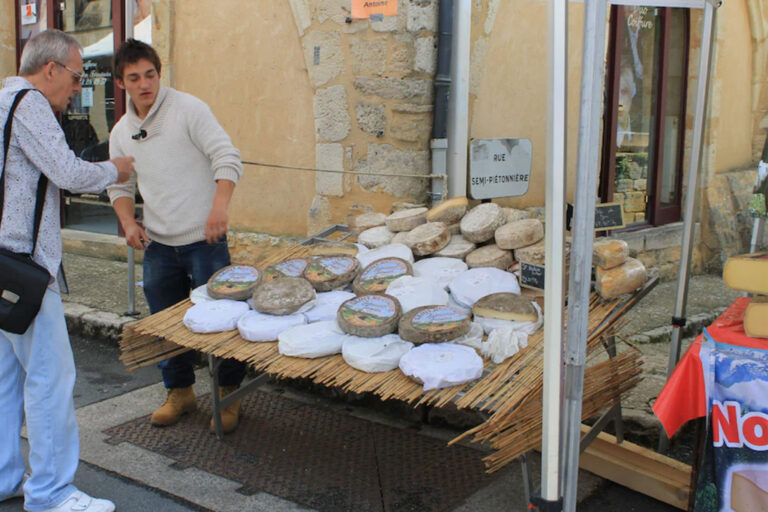 Assortment of locally produced cheeses and artisanal food products displayed at village market counter